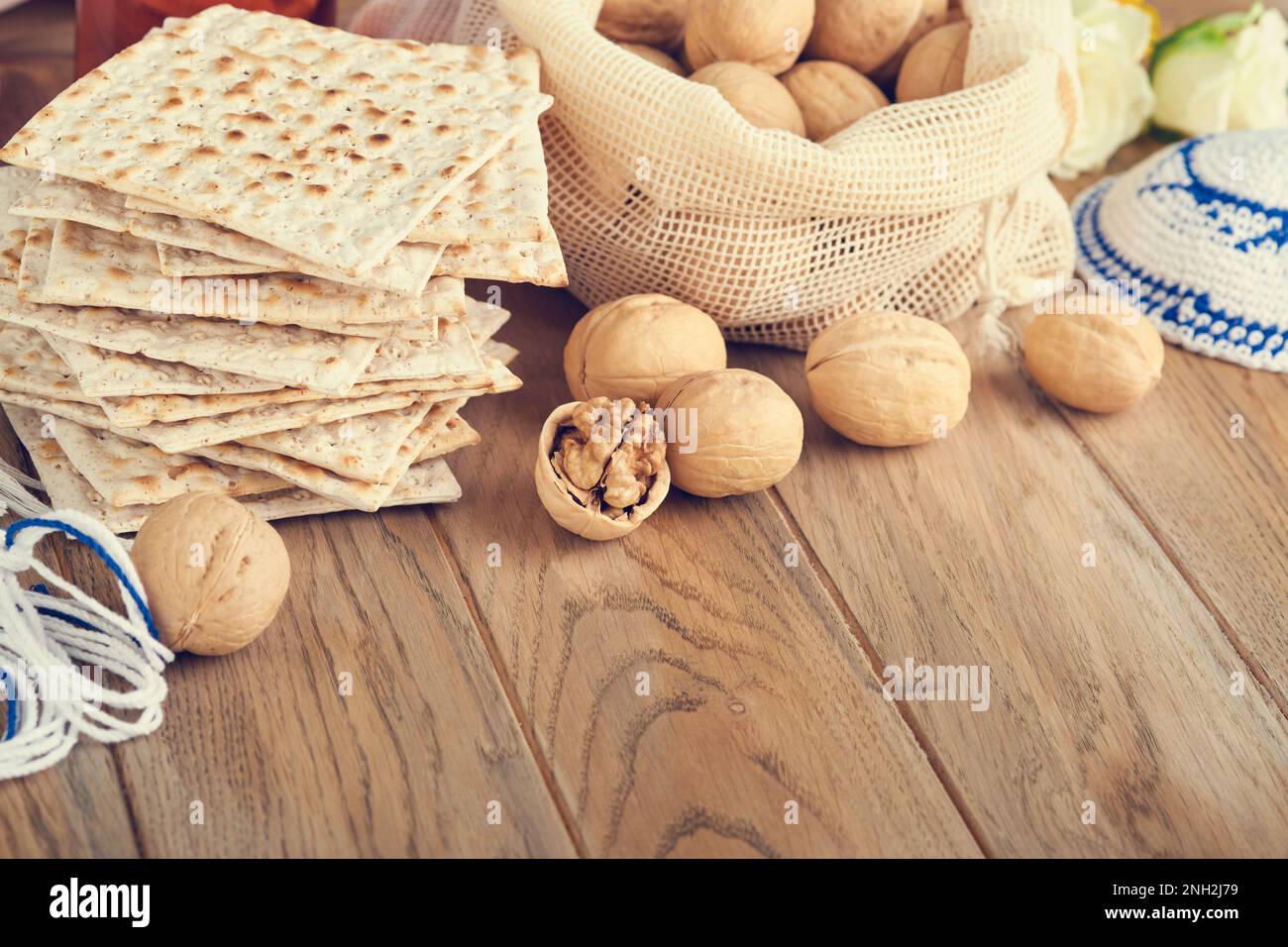 Das Konzept der Pessachstunde. Matzah, roter Koscher und Walnuss. Traditionelles jüdisches Brot Matzah, Kippah und Tallit auf altem Holzhintergrund. Passo Stockfoto