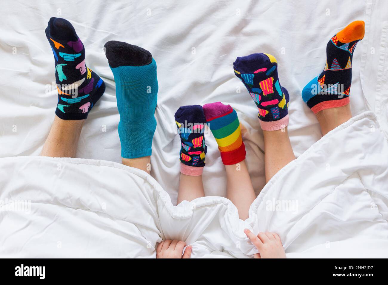 Bunte Socken an den Füßen als Symbol des Weltuntergangssyndroms. Stockfoto