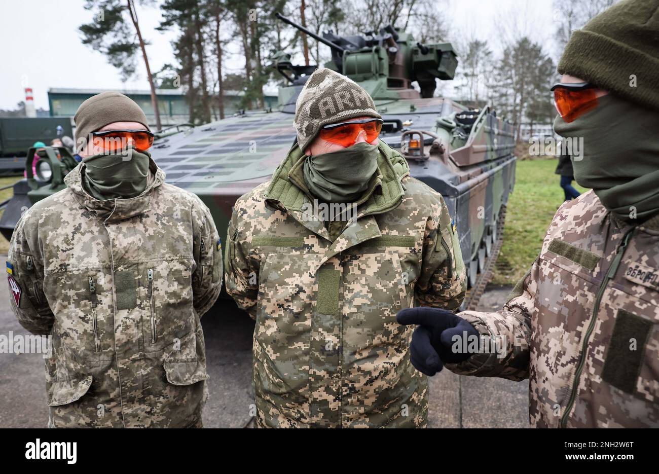 20. Februar 2023, Niedersachsen, Munster: Drei ukrainische Soldaten stehen vor einem Marder-Infanterie-Kampffahrzeug während eines Besuchs des deutschen Verteidigungsministers Pistorius in der Panzertruppenschule in Münster, Niedersachsen. Während seines Besuchs in Munster erfährt Pistorius mehr über die Ausbildung ukrainischer Soldaten auf deutschen Hauptpanzern und Infanteriefahrzeugen und hält Gespräche mit ukrainischen Soldaten und deutschen Ausbildern. Foto: Christian Charisius/dpa Stockfoto