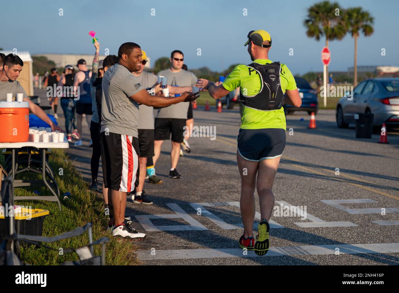 Mitglieder von Space Launch Delta 45 verteilen Wasser an T-minus-10-Miler-Teilnehmer an der Cape Canaveral Space Force Station, Florida, 10. Dezember 2022. Die Becher, die an den Hydrationsstationen verwendet wurden, waren wiederverwendbar, um Abfall zu vermeiden. Stockfoto