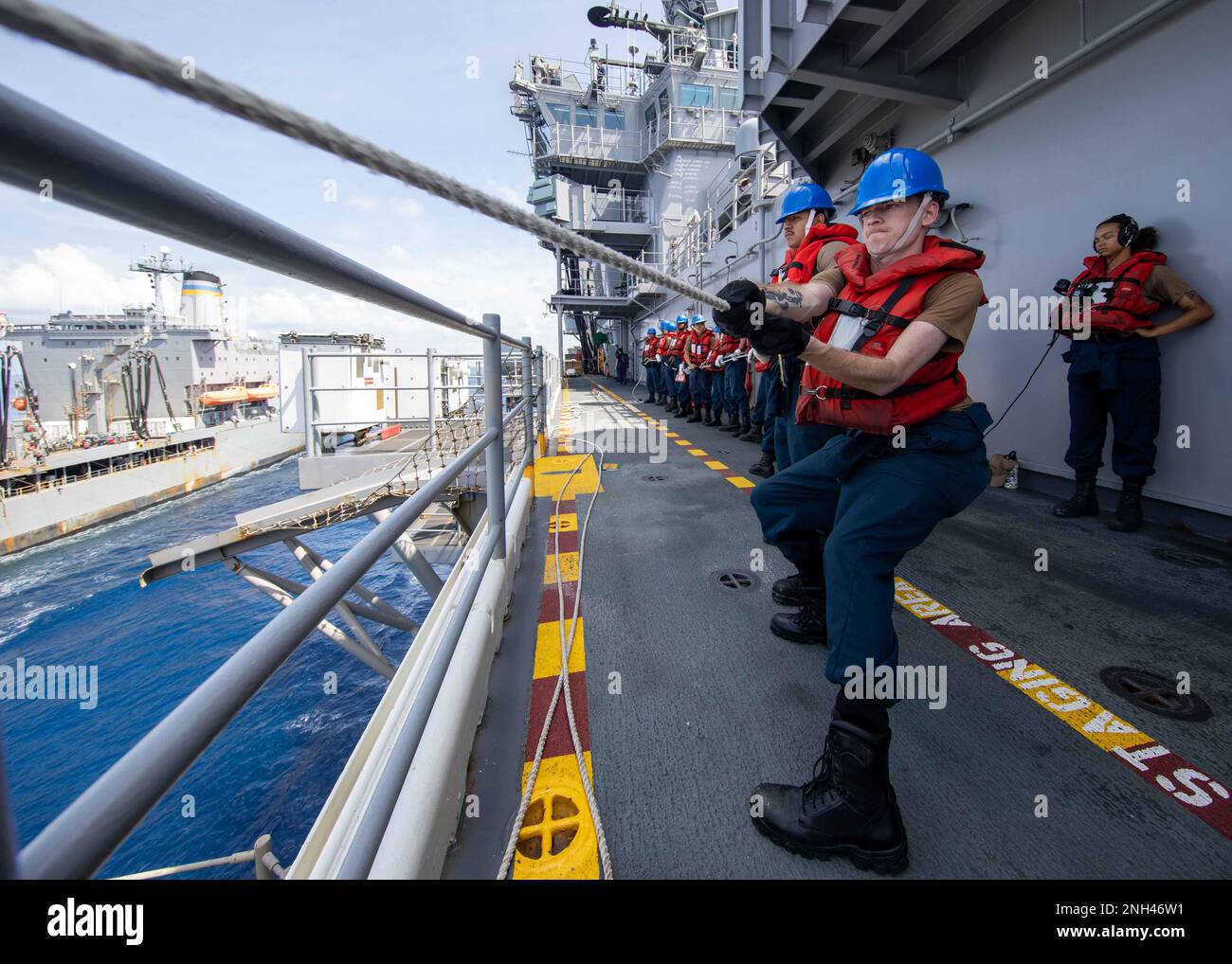 221211-N-IV962-1018 PHILIPPINE SEA (11. Dez. 2022) – Seeleute schnüren sich während einer Wiederauffüllung auf See an Bord des Amphibienschiffs USS Makin Island (LHD 8), 11. Dez. 2022. Commander, Logistics Group Western Pacific/Task Force 73 ist die USA Die führende Organisation der Marine für mobile Logistik, die das Siebte Flottengebiet unterstützt. Das Unternehmen befindet sich in Südostasien, COMLOG WESTPAC, in Zusammenarbeit mit dem militärischen Sealift-Kommando Far East und versorgt die USA logistisch Einsatzeinheiten der Marine im Westpazifik zusammen mit regionalen Alliierten und Partnern. Die Makin Island Amphibienfahrzeug Bereit Stockfoto