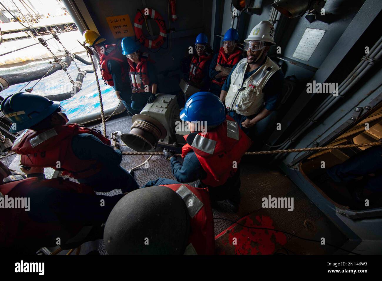 221211-N-IV962-1098 PHILIPPINE SEA (11. Dez. 2022) – Seeleute schnüren sich während einer Wiederauffüllung auf See an Bord des Amphibienschiffs USS Makin Island (LHD 8), 11. Dez. 2022. Commander, Logistics Group Western Pacific/Task Force 73 ist die USA Die führende Organisation der Marine für mobile Logistik, die das Siebte Flottengebiet unterstützt. Das Unternehmen befindet sich in Südostasien, COMLOG WESTPAC, in Zusammenarbeit mit dem militärischen Sealift-Kommando Far East und versorgt die USA logistisch Einsatzeinheiten der Marine im Westpazifik zusammen mit regionalen Alliierten und Partnern. Die Makin Island Amphibienfahrzeug Bereit Stockfoto