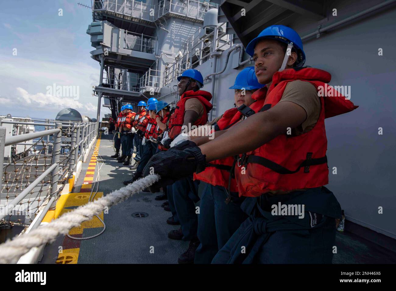 221211-N-VS068-1115 PHILLIPEAN SEA (11. Dez. 2022) – Seeleute heulen während einer Wiederauffüllung auf See an Bord des Amphibienschiffs USS Makin Island (LHD 8), 11. Dez. 2022. Commander, Logistics Group Western Pacific/Task Force 73 ist die USA Die führende Organisation der Marine für mobile Logistik, die das Siebte Flottengebiet unterstützt. Das Unternehmen befindet sich in Südostasien, COMLOG WESTPAC, in Zusammenarbeit mit dem militärischen Sealift-Kommando Far East und versorgt die USA logistisch Einsatzeinheiten der Marine im Westpazifik zusammen mit regionalen Alliierten und Partnern. Die Makin Island Amphibienfahrzeug Bereit Stockfoto