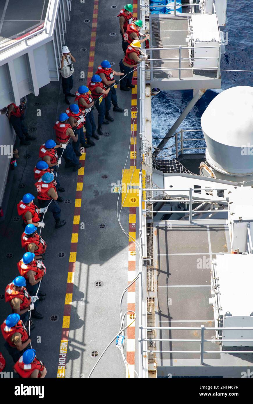 221211-N-VS068-1081 PHILLIPEAN SEA (11. Dez. 2022) – Seeleute heulen während einer Wiederauffüllung auf See an Bord des Amphibienschiffs USS Makin Island (LHD 8), 11. Dez. 2022. Commander, Logistics Group Western Pacific/Task Force 73 ist die USA Die führende Organisation der Marine für mobile Logistik, die das Siebte Flottengebiet unterstützt. Das Unternehmen befindet sich in Südostasien, COMLOG WESTPAC, in Zusammenarbeit mit dem militärischen Sealift-Kommando Far East und versorgt die USA logistisch Einsatzeinheiten der Marine im Westpazifik zusammen mit regionalen Alliierten und Partnern. Die Makin Island Amphibienfahrzeug Bereit Stockfoto