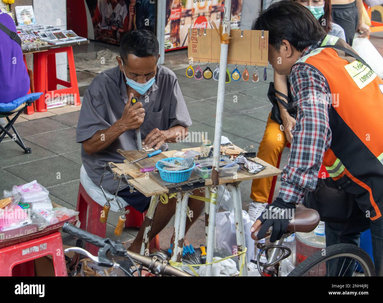 BANGKOK, THAILAND, FEBRUAR 04 2023, der Mann auf der Straße macht einen handgefertigten Koffer für Medaillen und Anhänger Stockfoto