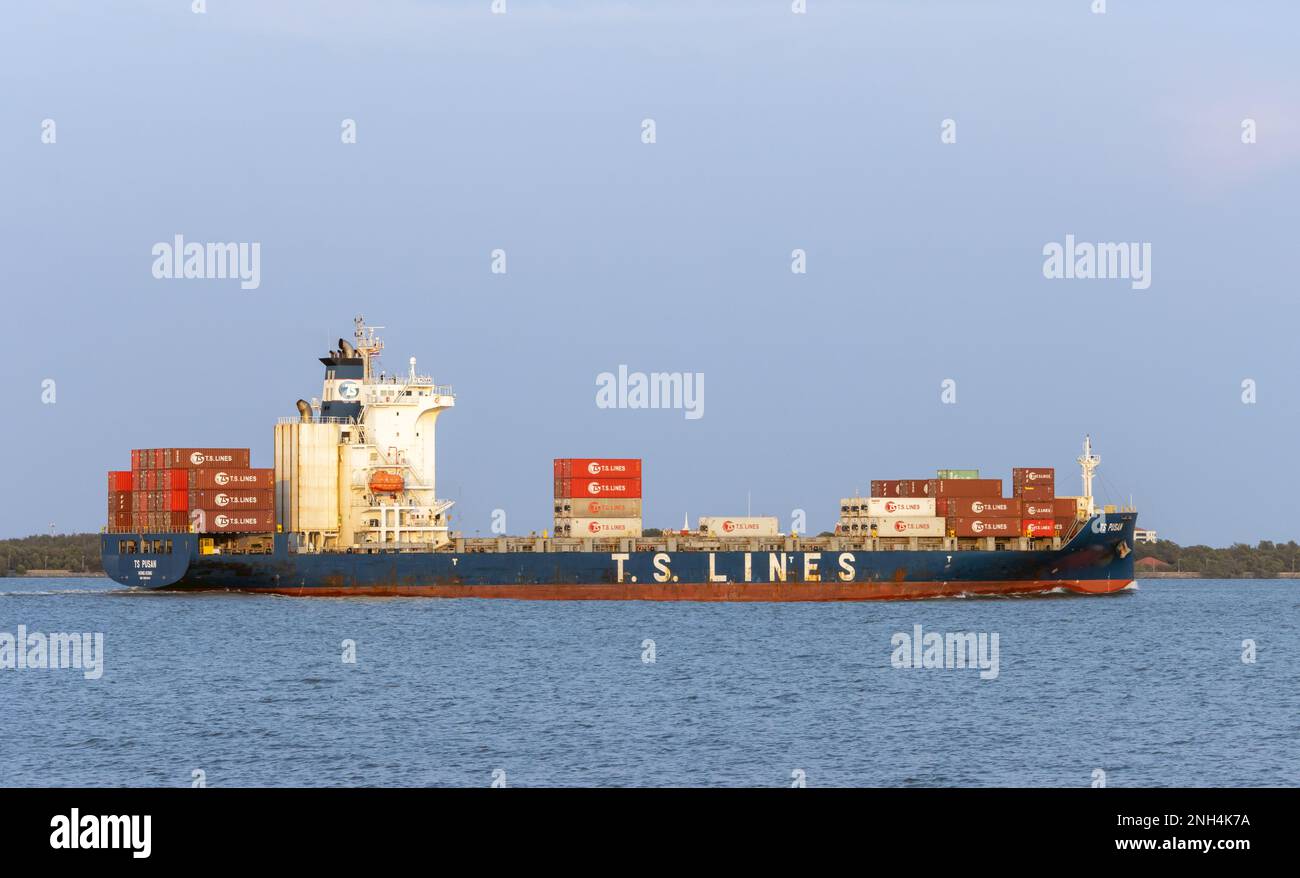SAMUT PRAKAN, THAILAND, 10. FEBRUAR 2023, The Ship TS PUSAN beladen mit Containern, segelt vom Fluss Chao Phraya zu einem offenen Meer bei Sonnenuntergang Stockfoto