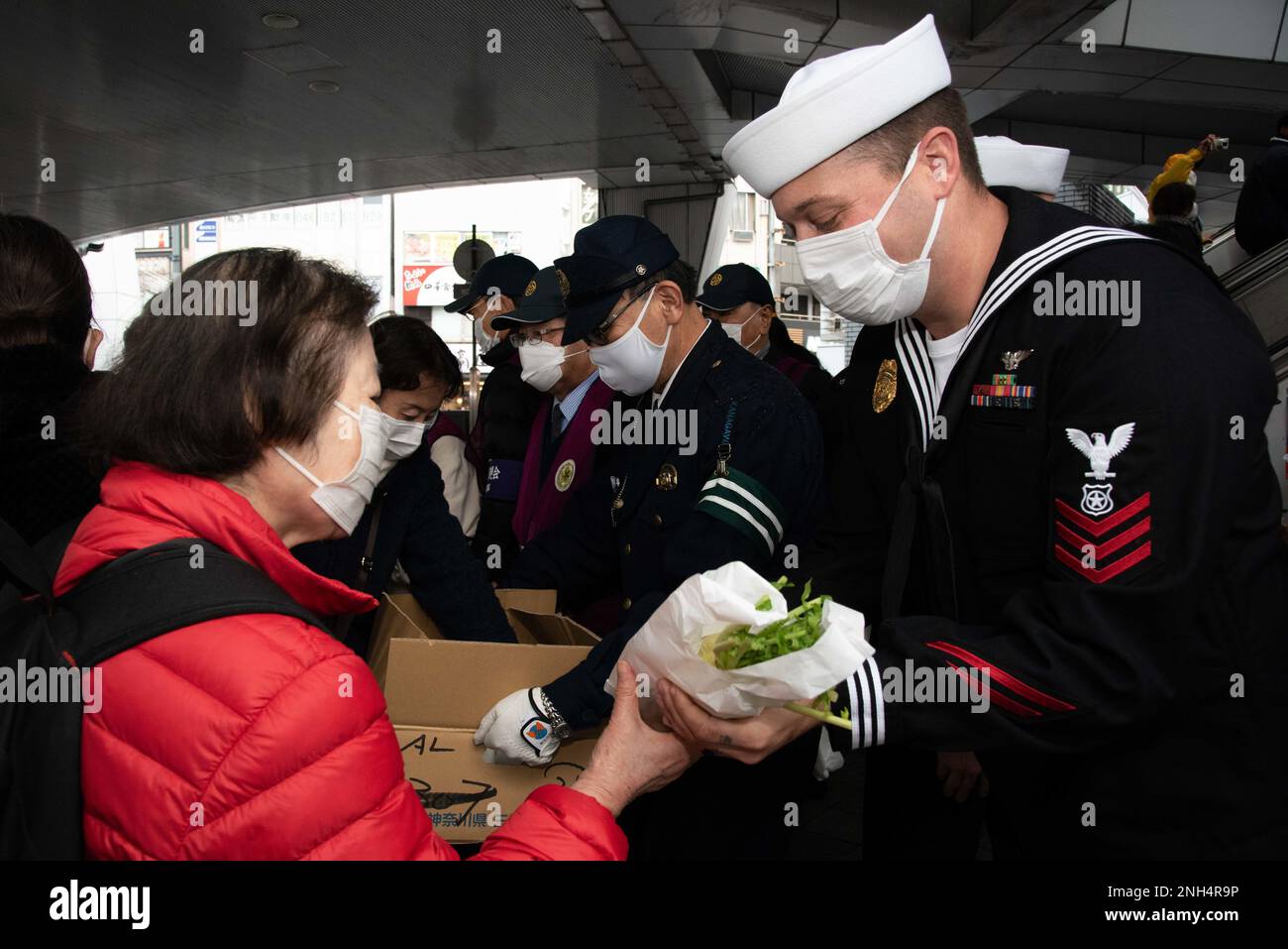 YOKOSUKA, Japan (13. Dezember 2022) — Matrosen, die dem Kommandeur, den Flottenaktivitäten Yokosuka (CFAY) und Mitgliedern der Sicherheitsabteilung von CFAY zugeteilt wurden, verteilen japanische Daikon-Radieschen an Fußgänger am Bahnhof Yokosuka Chuo während einer Veranstaltung, bei der das Bewusstsein für Trunkenheit am Steuer während der Weihnachtszeit geschärft wird. „Daikon“ ist ein Wortspiel, da es dem japanischen Wort „daikonzetsu“ sehr nahe kommt, d. h. der Ausrottung (des betrunkenen Fahrens). Seit mehr als 75 Jahren stellt CFAY Basiseinrichtungen und -Dienste zur Unterstützung der vorwärtsstationierten Marinetruppen, Mietbefehle und der US-amerikanischen 7.-Flotte bereit, pflegt und betreibt diese Stockfoto