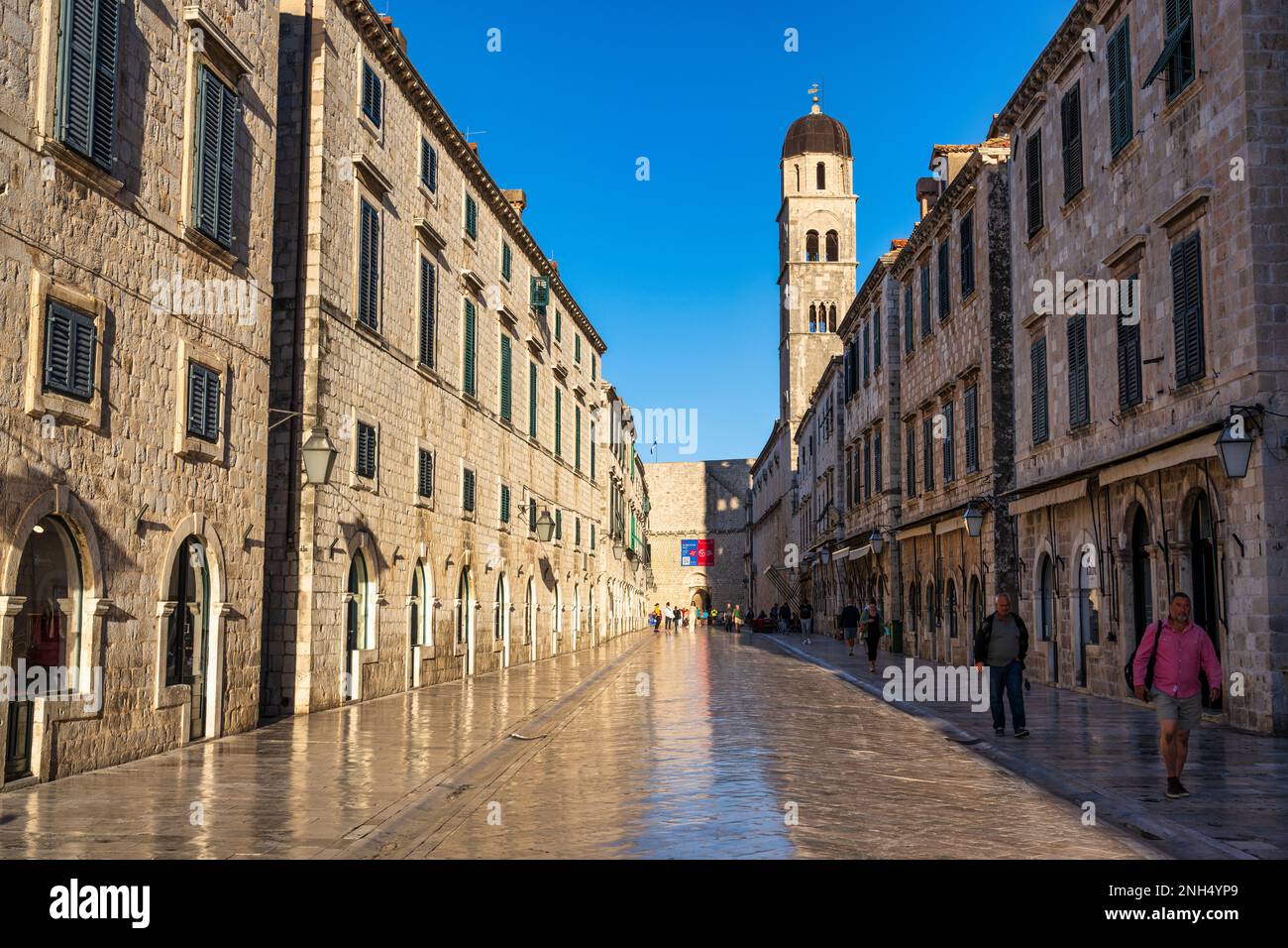 Am frühen Morgen auf der Stradun (Placa), mit Glockenturm der Franziskanerkirche auf der rechten Seite und Pile Gate dahinter, in der Altstadt von Dubrovnik in Kroatien Stockfoto