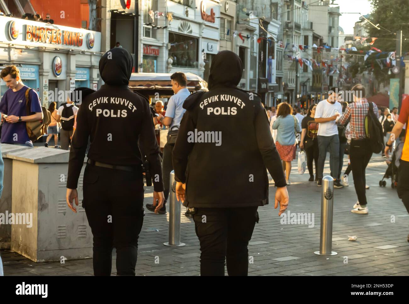 Weibliche Polizisten in schwarzen Burqas, Hijabs in der belebten Istiklal-Straße mit multikulturellen Menschenmengen in Zentral-Istanbul, Türkei Stockfoto