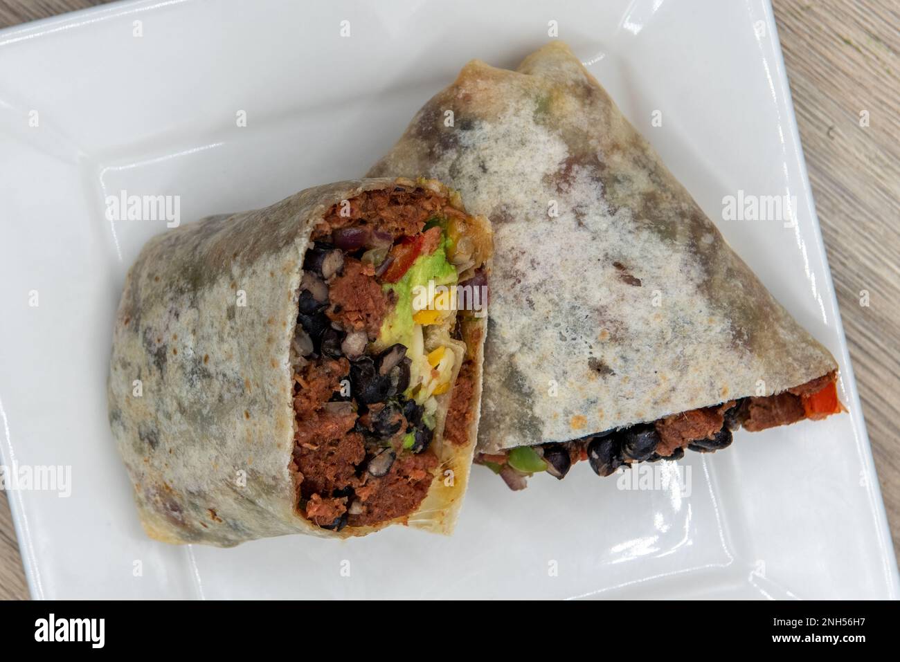 Overhead View der vegetarischen Version eines Frühstücks-Burrito ohne Fleisch für eine gesunde proteinhaltige Alternative. Stockfoto
