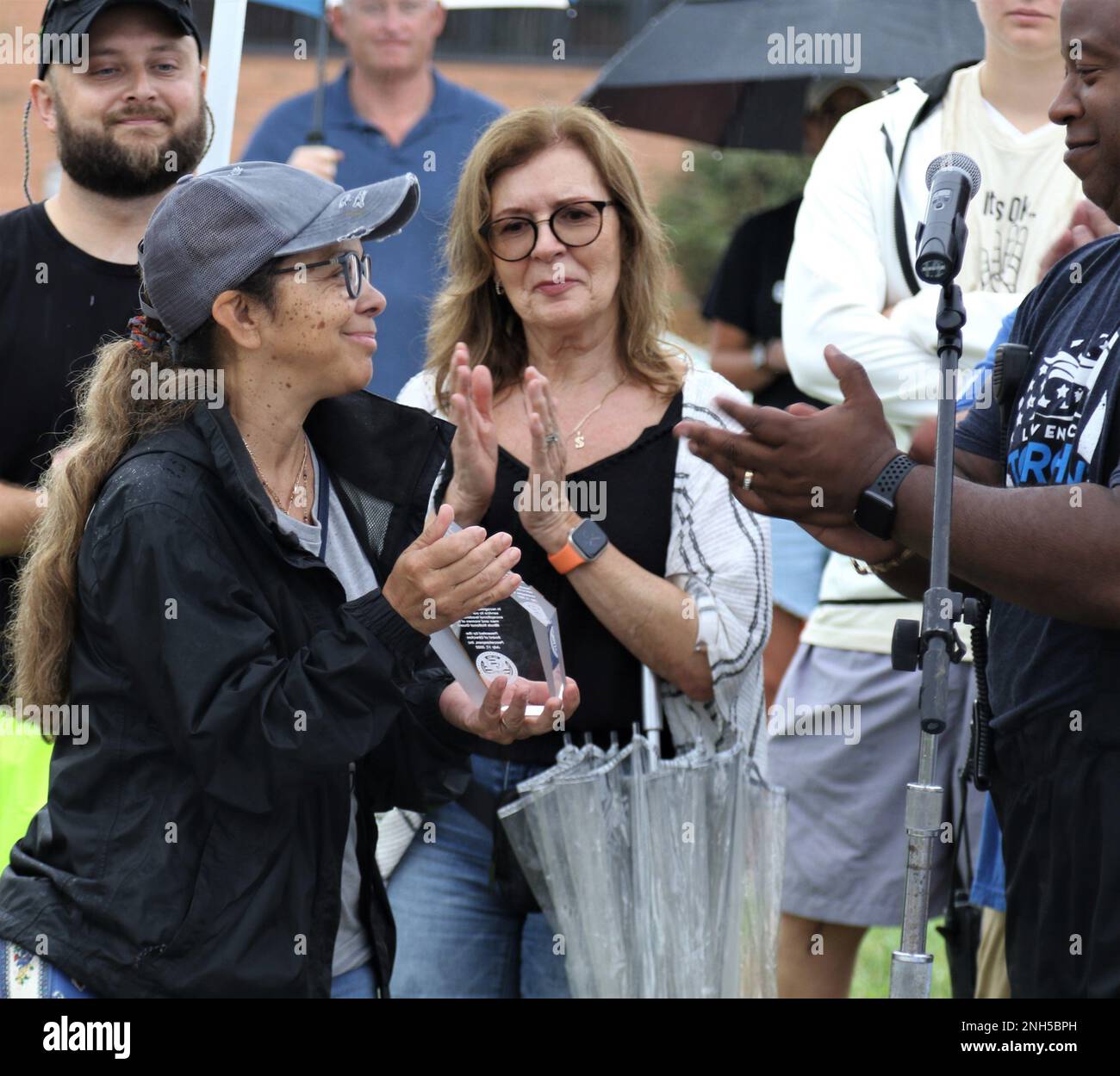 Nilsa Smith, die Witwe von Oberst James Smith, lächelt, nachdem sie eine Glastafel zu Ehren des jahrelangen Engagements des Oberst für Militärangehörige und Strafverfolgungsbeamte erhalten hat. Die jährliche Peacekeepers-Fahrt beginnt am Hauptquartier der Illinois National Guard in Camp Lincoln in Springfield. Dieses Jahr wurde der Ride am 17. Juli von der Illinois Army National Guard Col. (Ret.) James Smith und Sangamon County Sheriff Department, Sergeant Jason Boesdorfer, beide starben im Mai. Smith diente 31 Jahre lang bei der Illinois Army National Guard und trat 2008 als Stabschef der ILARNG in den Ruhestand. Er war es dann Stockfoto