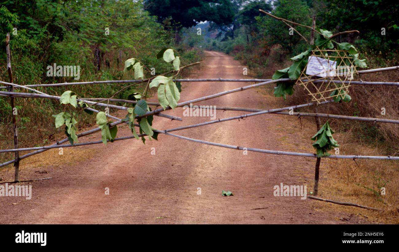 Ein Zaun blockiert die Straße, um potenzielle Außenstehende zu warnen, sich von dem animistischen Ritual fernzuhalten, das in einem einheimischen Dorf in Tampuan stattfindet. Stockfoto