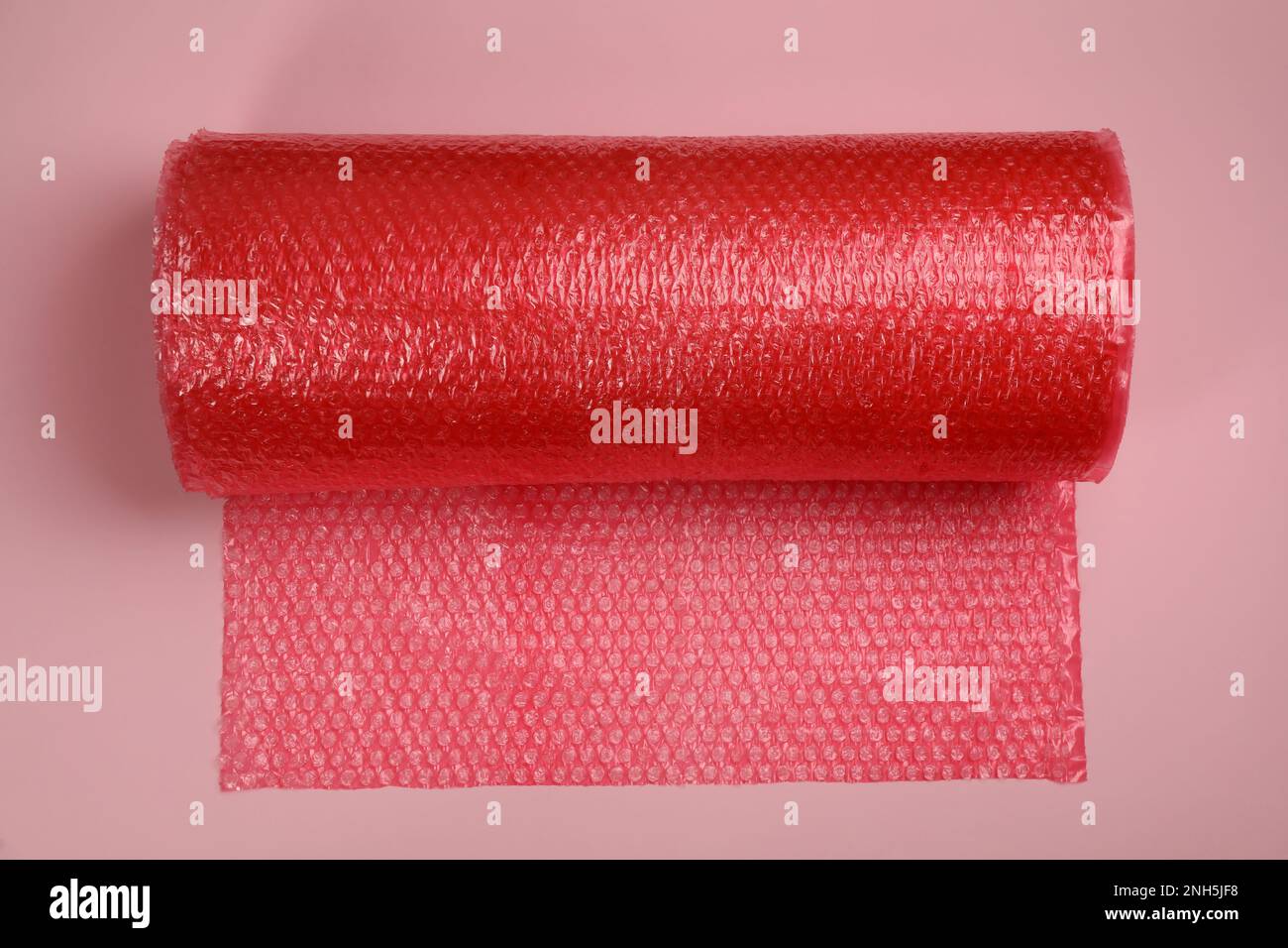Luftpolsterrolle auf hellrosa Hintergrund, Draufsicht Stockfoto