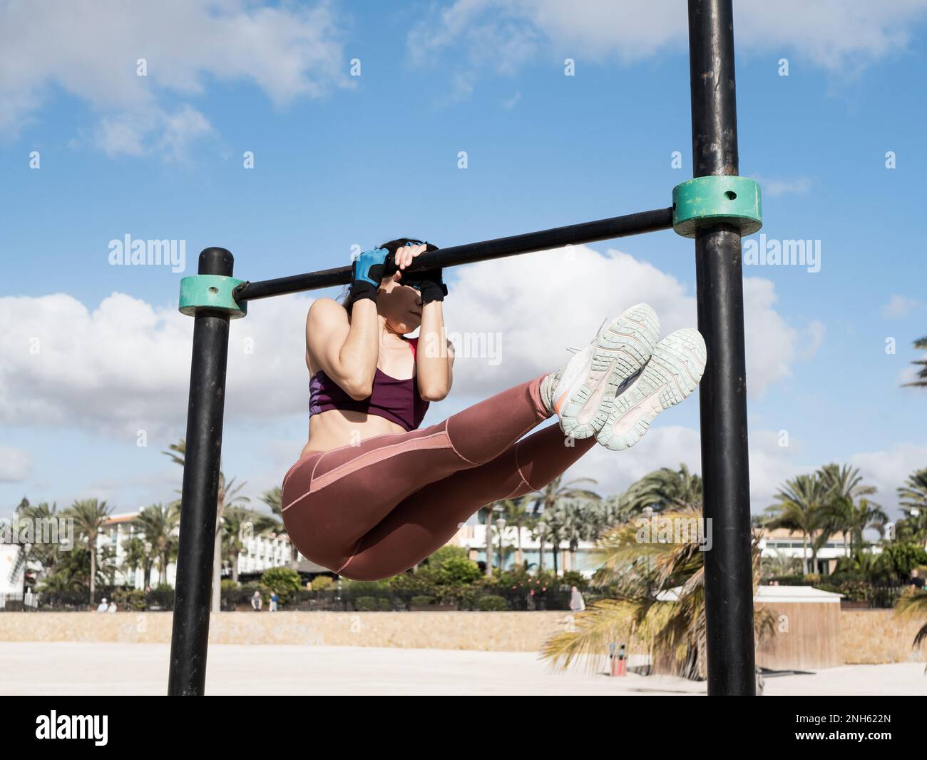 Eine junge hispanikerin, die draußen im Calisthenics Park trainiert Stockfoto