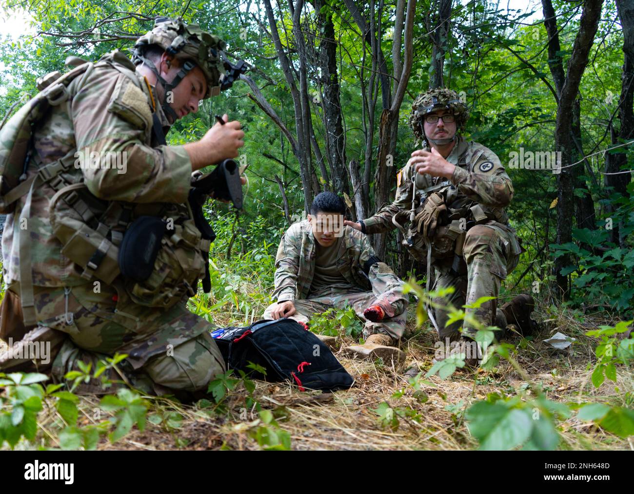 Sanitäter der Charlie Company, 1. Bataillon, 181. Infanterie-Regiment, 44. Infanterie-Brigade-Kampfteam leisten erste Hilfe an einem Soldat, der während der Exportable Combat Training Capability (XCTC) Übung in Fort Drum, New York, am 19. Juli 2022 eine feindliche Kriegsgefangenschaft spielt. Mehr als 2.500 Soldaten nehmen an der Schulung Teil, die es den Brigaden-Kampfteams ermöglicht, die ausgebildete Zugbereitschaft zu erreichen, die für Einsatz, Kampf und Sieg erforderlich ist. Die Soldaten der 181. sind Teil der Massachusetts Army National Guard und der Rest der 44. Infanteriebrigade besteht aus Einheiten von Stockfoto