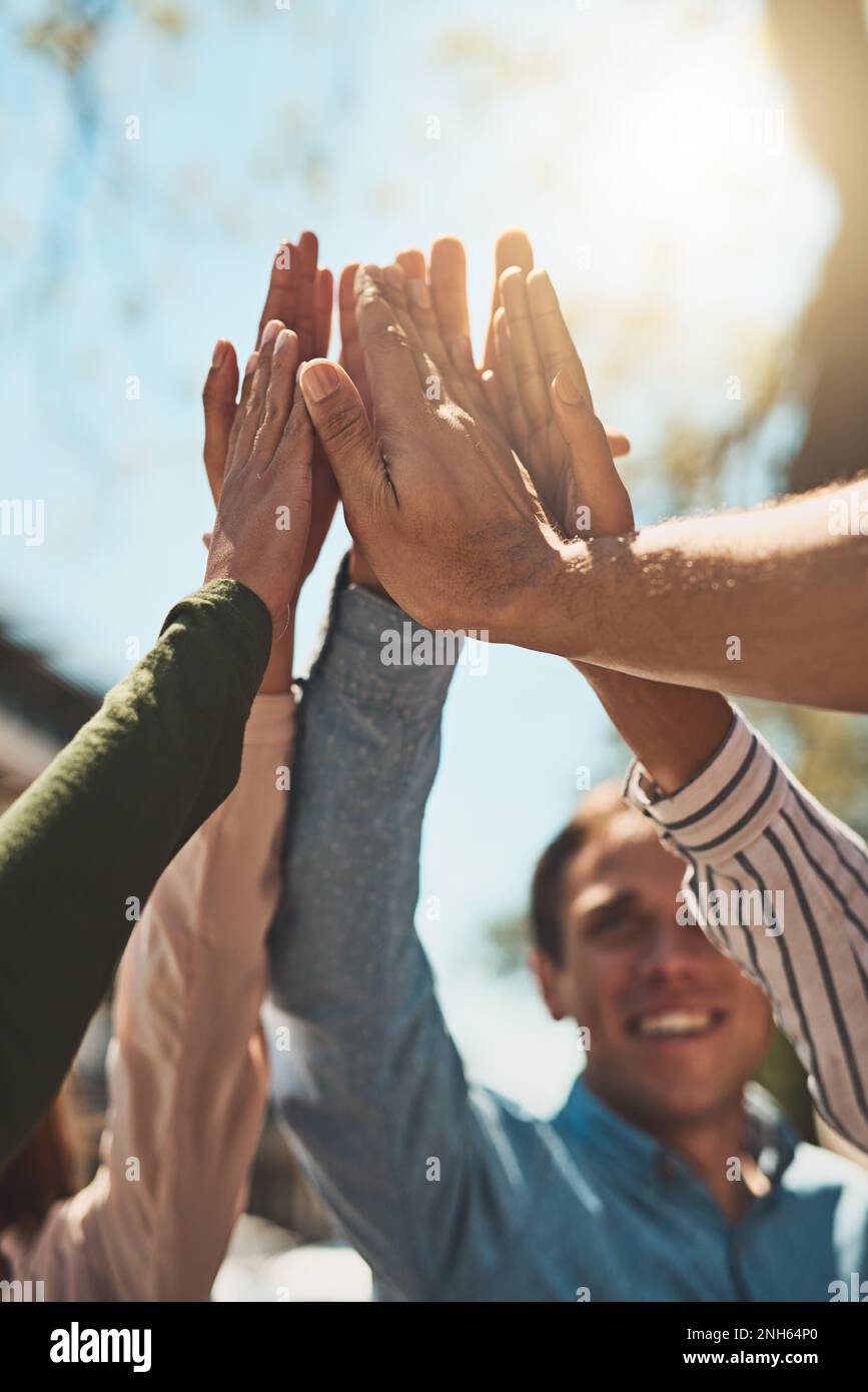Die sollen hoch gehen. Eine Gruppe fröhlicher junger Freunde, die sich zusammendrängen und sich tagsüber draußen ein paar High Five geben. Stockfoto