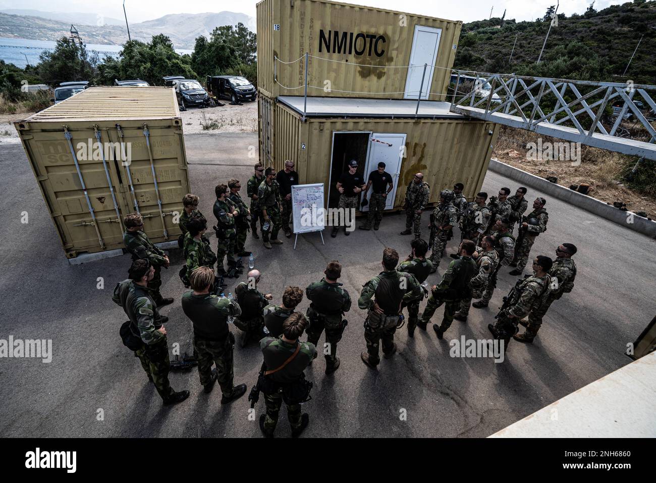 USA Aufklärungsmarines mit Sonderausbildungsabteilung, Ausbildungsgruppe für Expeditionsoperationen, I Marine Expeditionary Force führen eine Nachbesprechung über einen Angriff durch, der von griechischen Armeesoldaten mit 1. Jägern-Fallschirmjägern-Brigade und schwedischen Marines mit 4. Marineregiment durchgeführt wurde. Schwedisches Amphibienkorps während der Übung TYR 22 im NATO Maritime Interdiction Operational Training Centre (NMIOTC) in Souda Bay, Griechenland, 20. Juli 2022. TYR 22 ist eine maritime Sperrübung, die bei der NMIOTC stattfindet und schwedische Marines aus den USA zusammenbringt Marines, USA Marinespezifische Kampfhubschrauber an mich Stockfoto