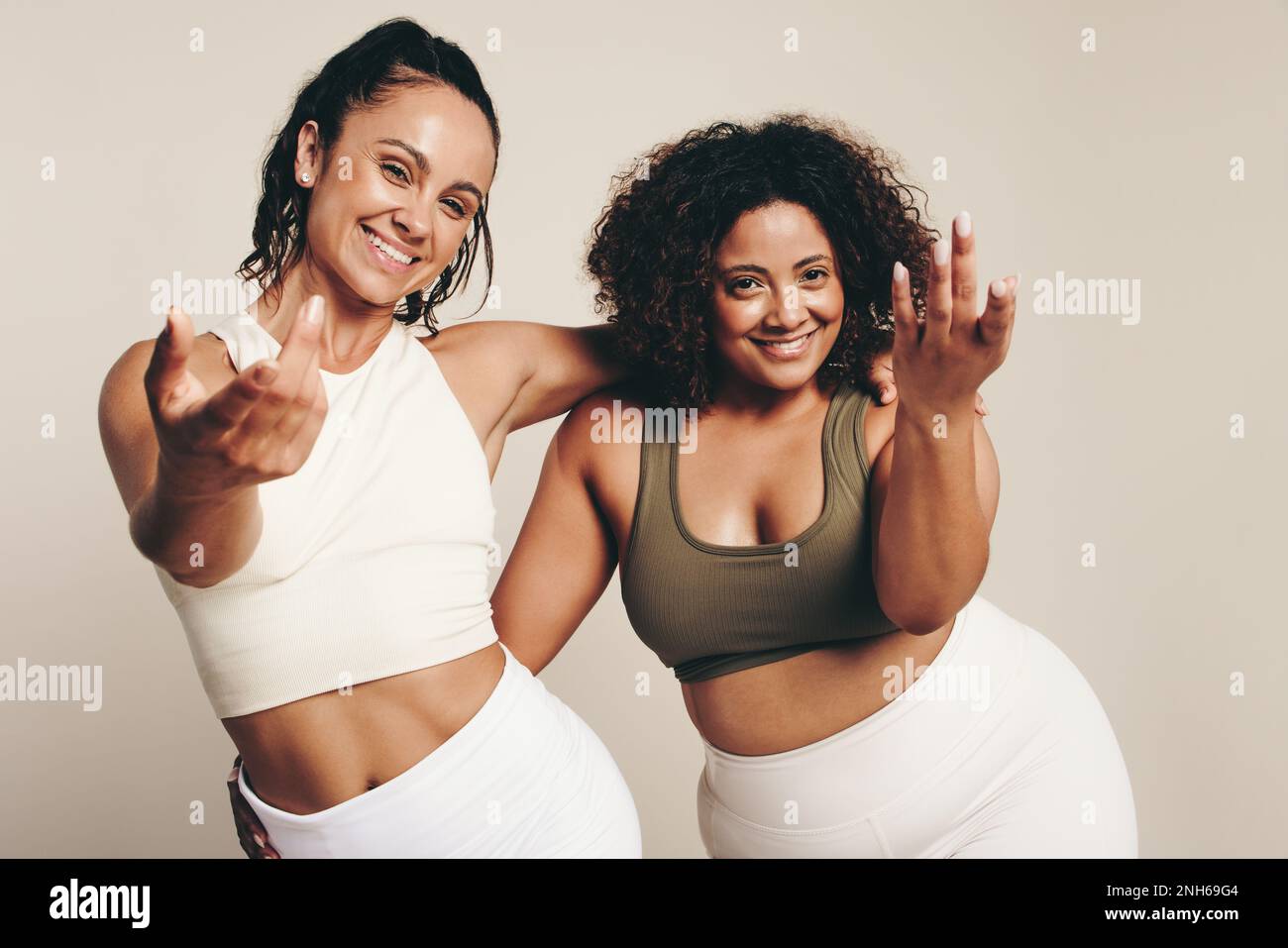 Zwei junge Frauen in Sportbekleidung tanzen und trainieren zusammen und verkörpern einen gesunden und aktiven Lebensstil. Energische Sportlerinnen, die ihre Schia ausdrücken Stockfoto