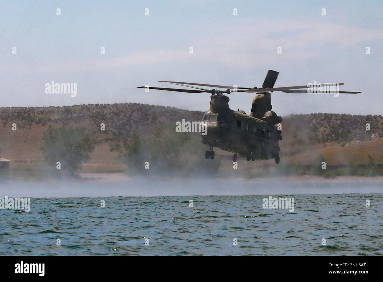 Eine Boeing CH-47 Chinook fliegt während des Team Leader Training Events am 19. Juli 2022 in Wyoming über den Grayrocks Reservoir. Soldaten im Helikopter sprangen dann heraus, wenn er den Absetzbereich erreichte. Stockfoto