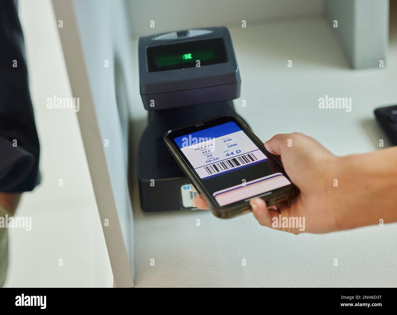 Hands-, Telefon- und Ticket-Scan am Flughafen für Reise-, Einwanderungs- oder Transportservice im Terminal. Hand des Reisenden, die das Smartphone online scannt Stockfoto