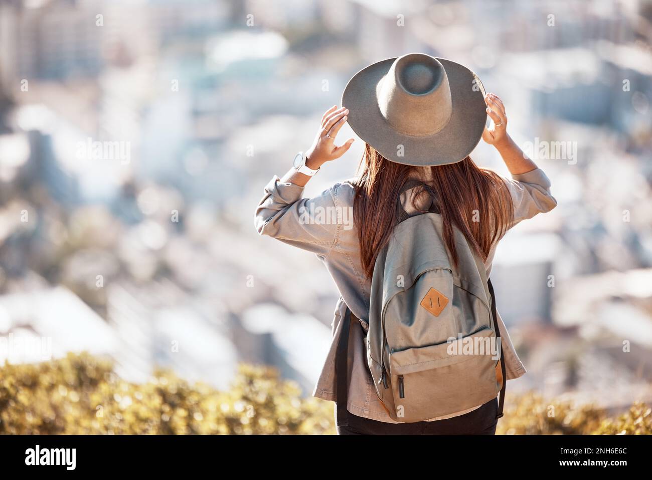 Zurück-, Berg- und Stadtblick für Wanderungen, Reisen und Natur für Urlaub, Sommer und Wellness Ziel. Mädchen, Entdecker und Berge mit Stadt Stockfoto