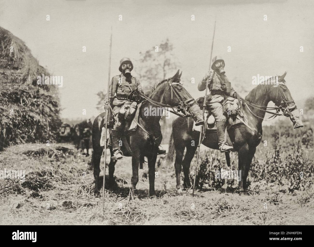 1914-1918. Erster Weltkrieg Dieses Porträt zeigt zwei deutsche Kavalleriesoldaten, bewaffnet mit Lanzen, genannt Ulane. Sowohl Männer als auch Pferde tragen Gasmasken. Stockfoto