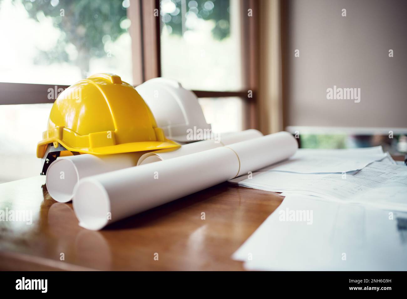 Gelber und weißer Helmhelm für harte Sicherheitskleidung auf Baustelle aufgeklebt. Stockfoto