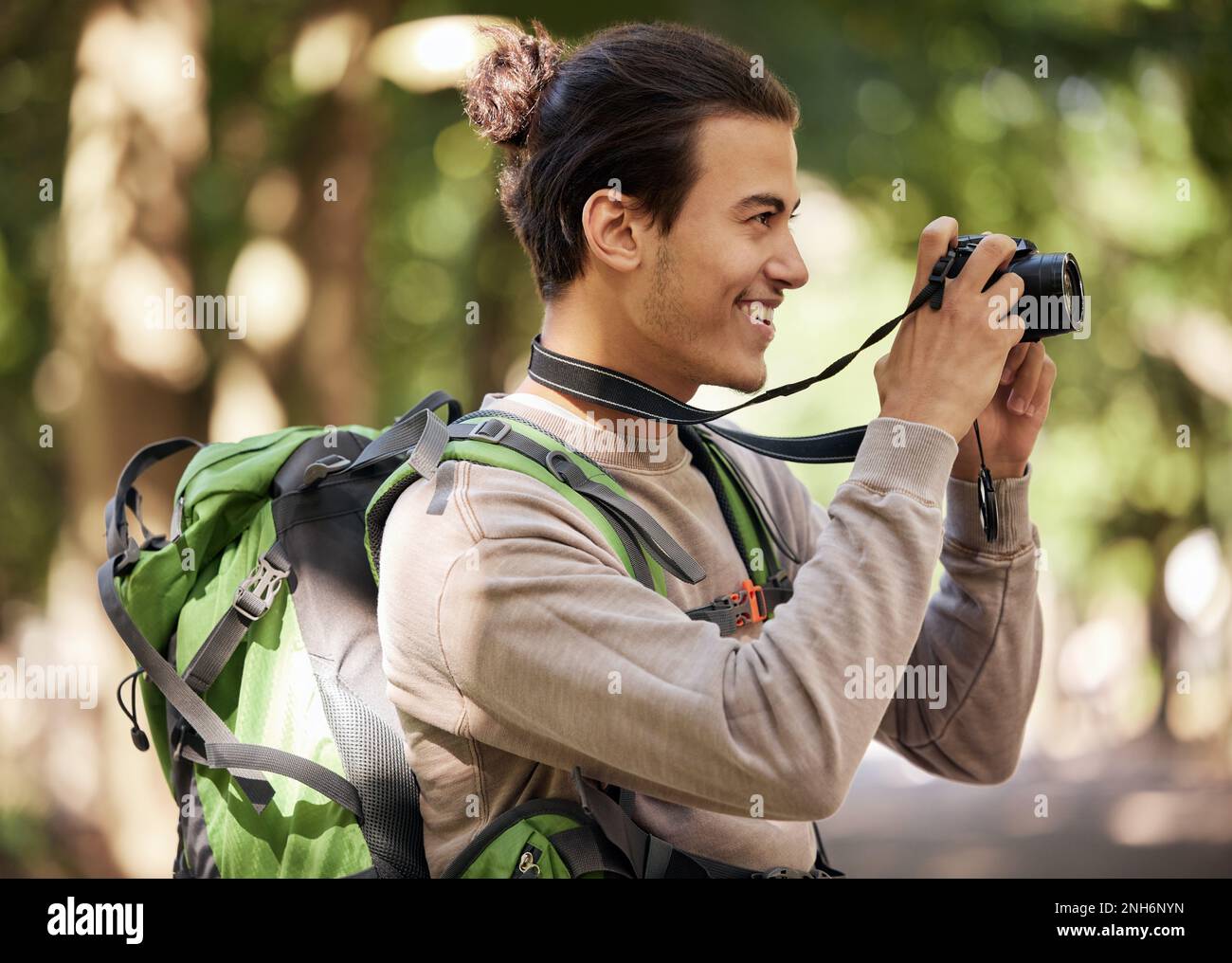 Fotograf, Kamera und Außenpark mit Lächeln, Fokus oder Abenteuer mit kreativer Vision. Junger Naturjournalist, Fotograf und Vogel Stockfoto