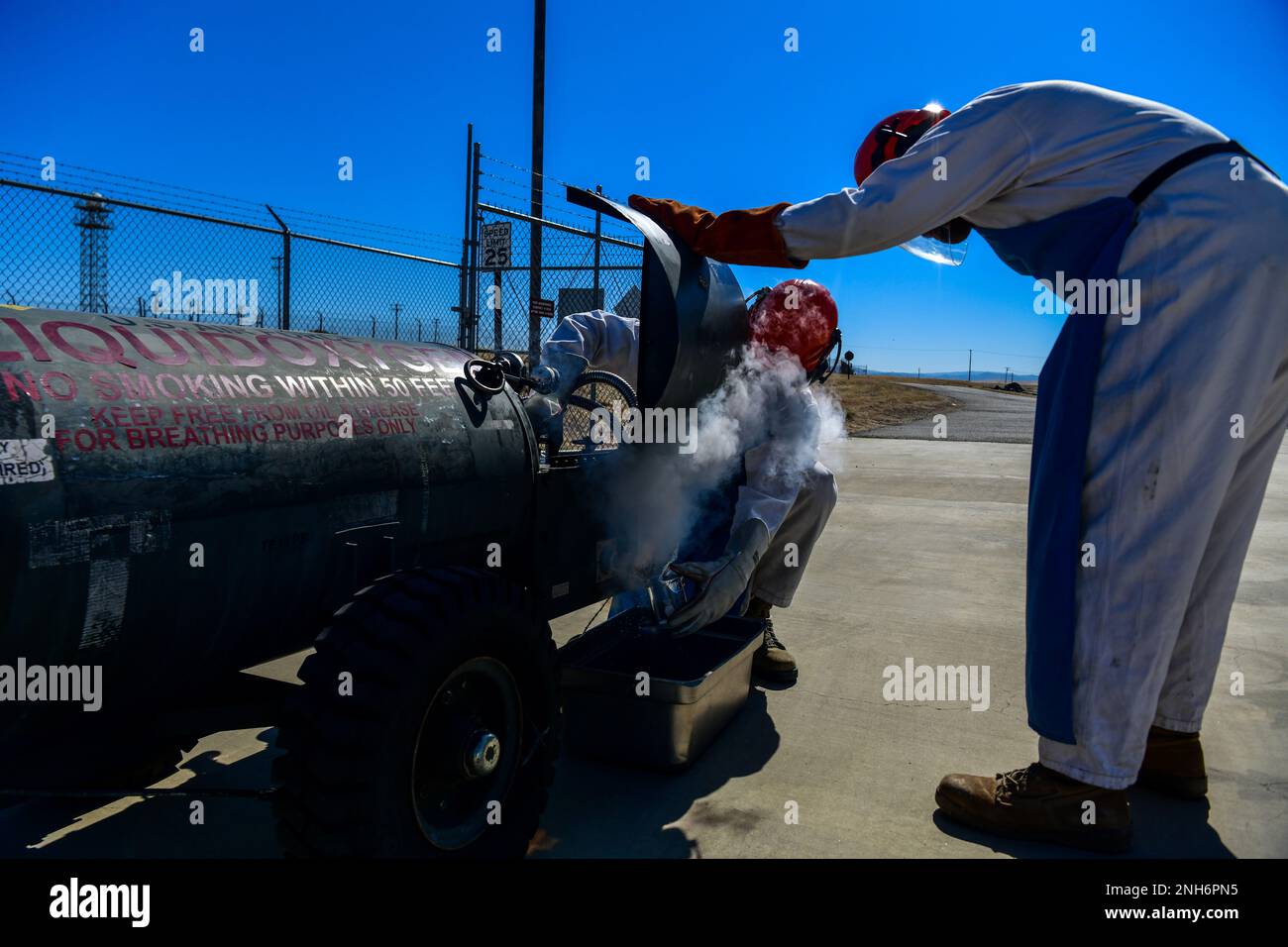 Senior Airman Verdes Cato beobachtet Airman 1. Class Randy Willis 9. Logistic Readiness Squadron Kryogenics Techniker, während er mit flüssigem Sauerstoff (LOX) vorsichtig umgeht, während eine U-2 Dragon Lady am Beale Air Force Base, Kalifornien, am 21. Juli 2022 rüberfliegt. Mit spezieller Schutzausrüstung sind Flugzeuge in der Lage, die Gefriertemperaturen des LOX zu bewältigen, um Verbrennungen zu vermeiden. Stockfoto