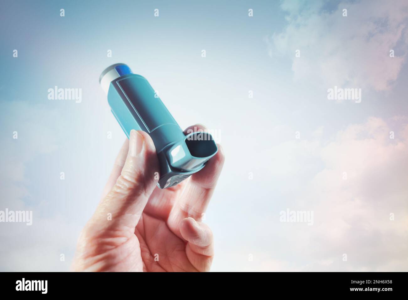 Hand halten einen Inhalator mit Spray als Notfallmedikation für einen Asthmaanfall, eine Allergie oder andere Lungenerkrankung mit Kurzatmigkeit, Kopierraum, s Stockfoto