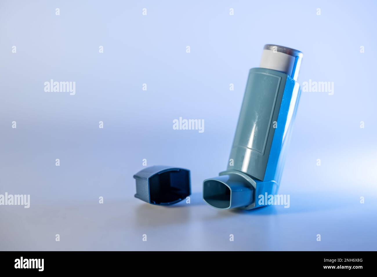 Blauer Inhalator, auch bekannt als Pumpe oder Allergiespray, medizinisches Gerät für Asthma- oder COPD-Patienten, Kopierraum, ausgewählter Fokus, schmale Schärfentiefe Stockfoto