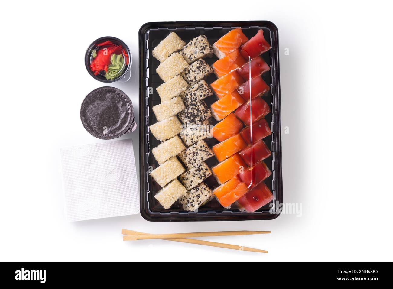 Sushi-Set mit Wasabi, Ingwer und Sojasoße, serviert in einer Plastikbox zum Mitnehmen. Gemischtes japanisches Sushi mit Thunfisch, Lachs, Sesam isoliert auf WH Stockfoto