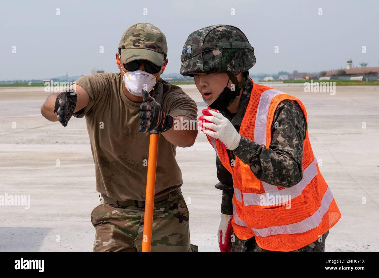 USA Air Force Senior Airman Sebastian Nunez, ein Operations Management Journeyman, spricht mit einem Mitglied der Luftwaffe der Republik Korea während eines Trainings zur raschen Reparatur von Flugplatzschäden am 20. Juli 2022 am Luftwaffenstützpunkt Gwangju, Republik Korea. Während der kombinierten Schulung haben die Mitglieder der USAF und der ROKAF ihre Interoperabilität verbessert, indem sie gemeinsam daran gearbeitet haben, Krater in einem Zementschulungspad zu befestigen. Stockfoto