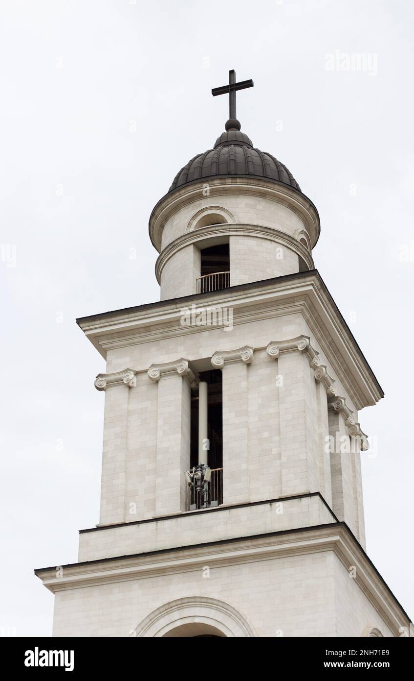Oberer Teil des Kirchenglockenturms mit einem Kreuz, ein architektonisches Gebäude im klassischen Stil, vor dem Hintergrund des Himmels Stockfoto