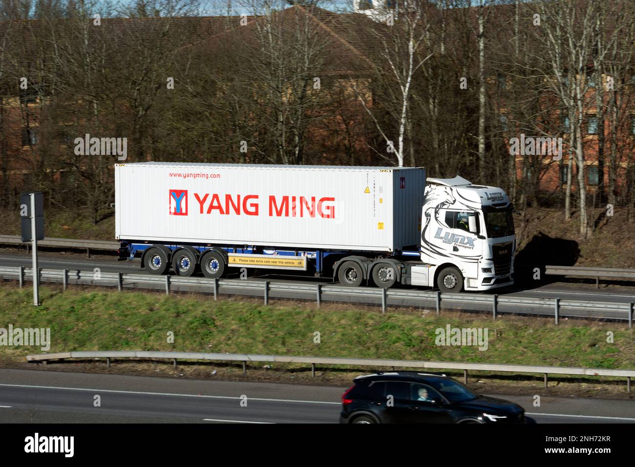 Lastkraftwagen mit einem Yang Ming-Schiffscontainer, der an der Anschlussstelle 15, Warwick, Warwickshire, Großbritannien, auf die Autobahn M40 gelangt Stockfoto