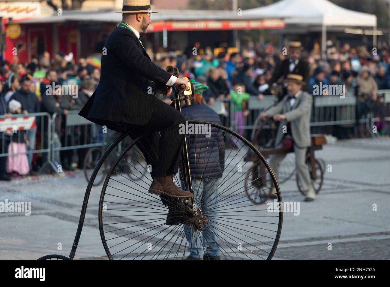 Nostalgie aus dem 19. Jahrhundert: Karnevalsbesucher fahren auf einer Penny Farthing Stockfoto