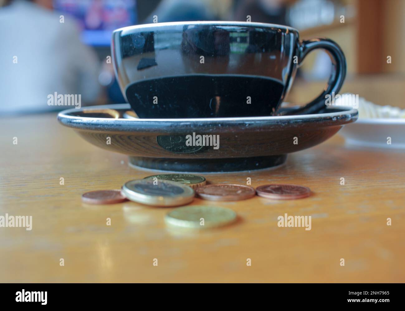 Der Preisanstieg für eine Tasse Kaffee, Münzen auf dem Tisch Stockfoto