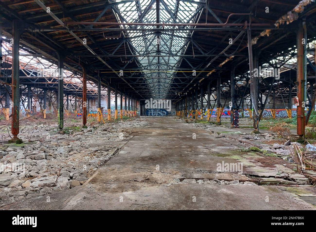 Riesige verlassene Fabrik mit beschädigtem Betonboden. Stockfoto