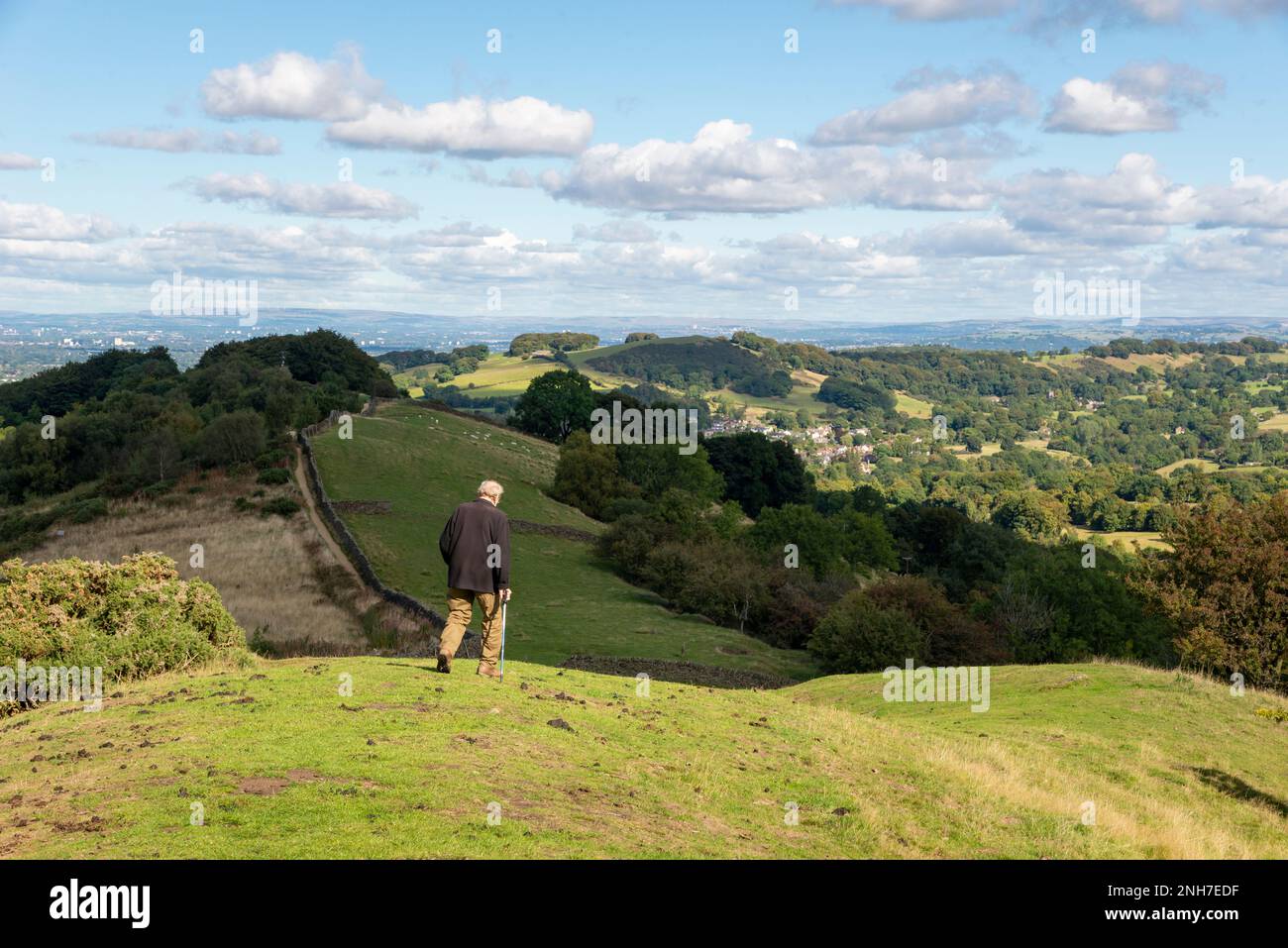 Ein erwachsener Mann, der auf dem Gritstone Trail auf dem Kerridge Hill in der Nähe von Bollington, Macclesfield, Cheshire, England läuft. Stockfoto