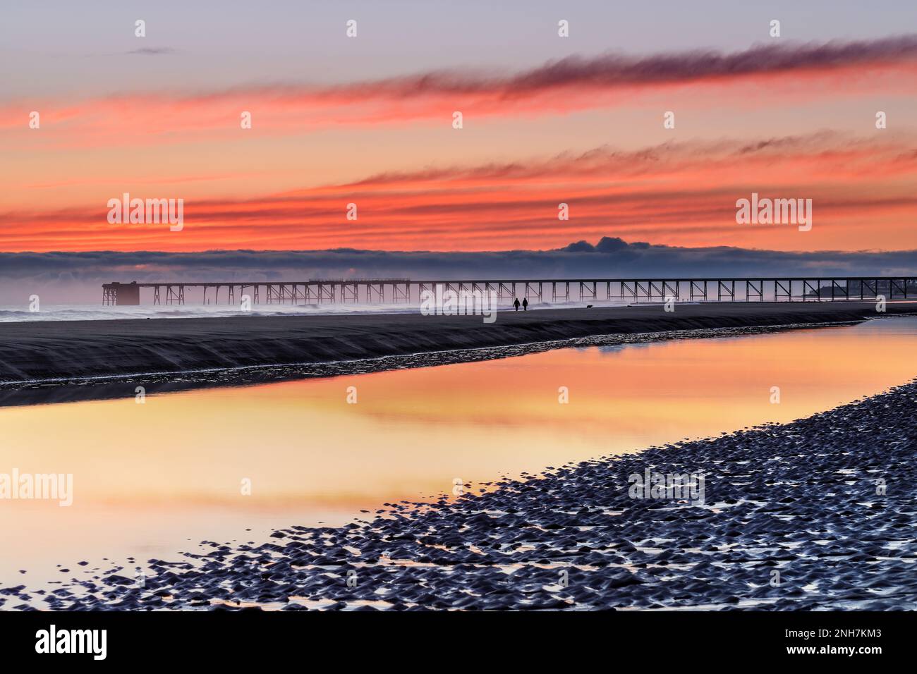 Zwei Personen in Richtung Industrial Relic of Steetley Pier in Dawn, Hartlepool, County Durham, Großbritannien. Stockfoto