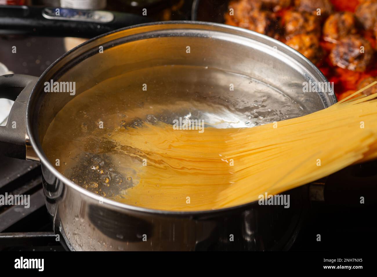 Tauchen Sie die Spaghetti in kochendes Wasser in einen Topf. Pasta-Kochen. Stockfoto