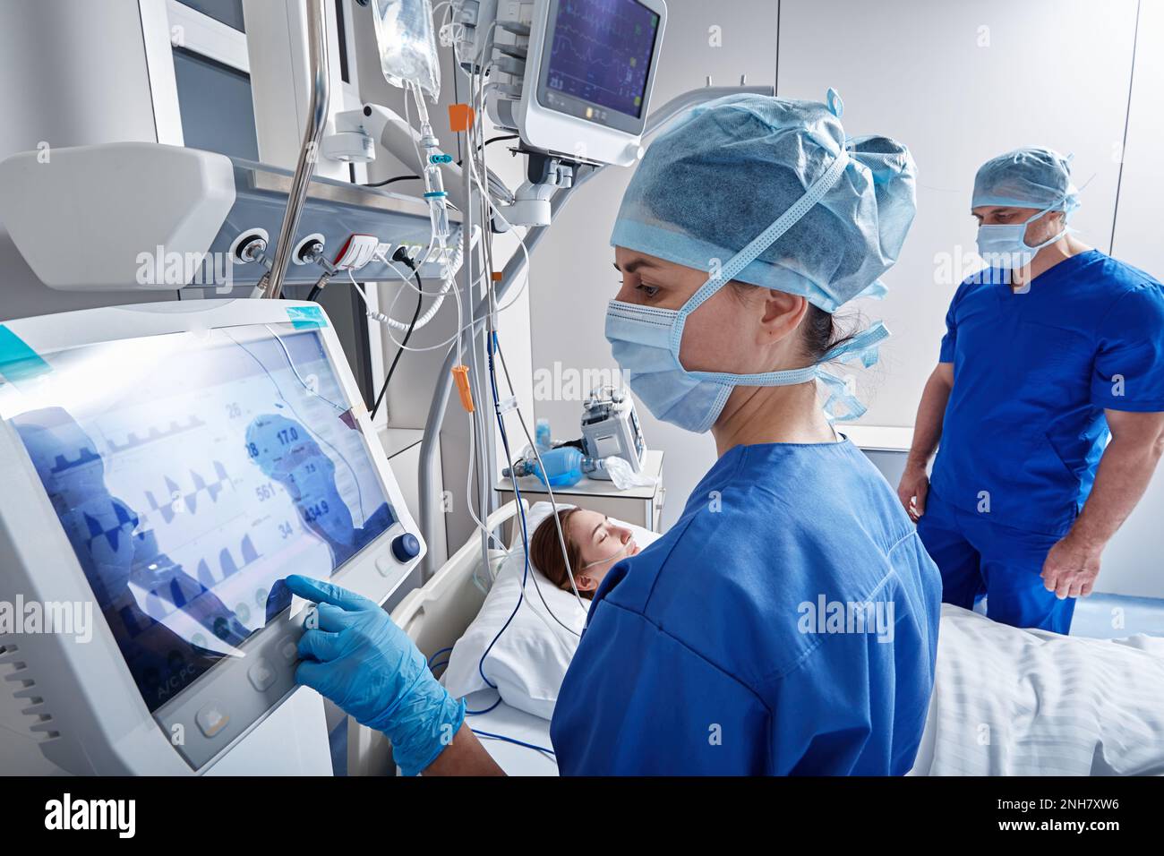 Krankenhauspfleger überprüfen auf der Intensivstation die Patientinnen und überwachen ihre Gesundheit mit medizinischen Geräten und Sensoren. INTENSIVSTATION Stockfoto
