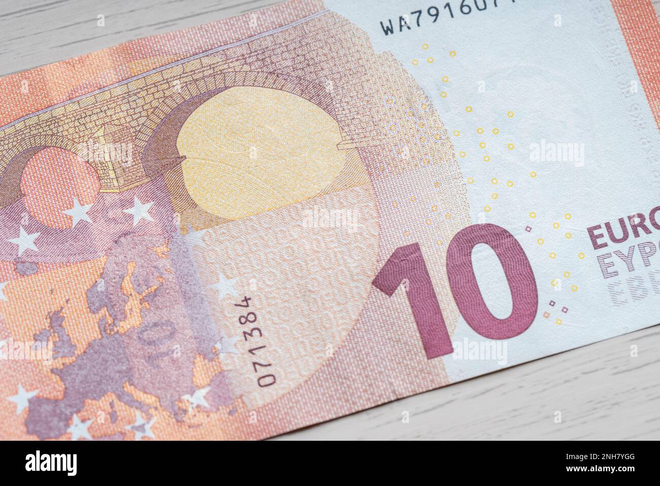 Nahaufnahme der 10-Euro-Banknote, Tischhintergrund aus Holz für Themen der Unternehmensfinanzierung. Weltwährungskonzept, Inflation und Wirtschaftskonzept. Die Währung ist nah dran Stockfoto