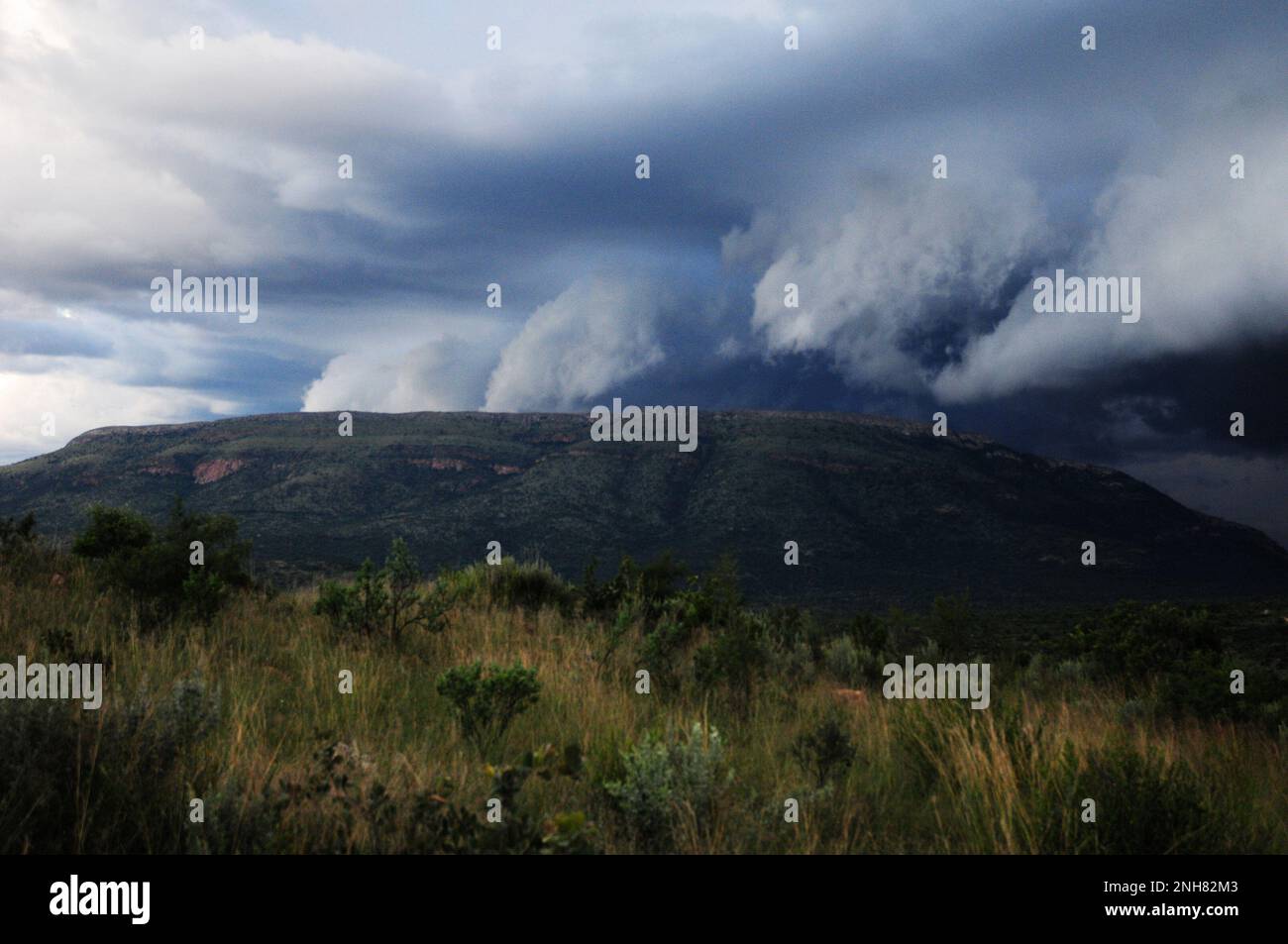 Gewitterwolken sammeln sich über einem afrikanischen Dorf, während Teile des Südostens Afrikas von extremen Wetterbedingungen heimgesucht werden Stockfoto