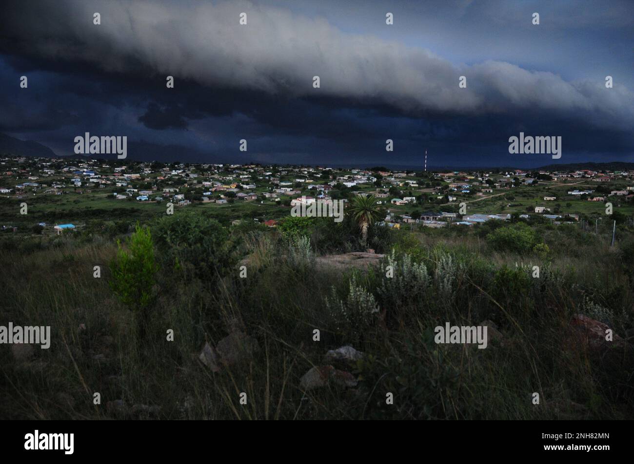 Gewitterwolken sammeln sich über einem afrikanischen Dorf, während Teile des Südostens Afrikas von extremen Wetterbedingungen heimgesucht werden Stockfoto