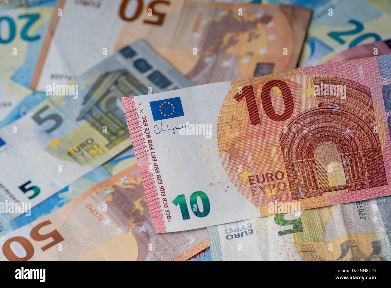 Ein Stapel Banknoten auf dem Tisch. Zehn Euro-Papiergeld im Fokus. Gemischte Euro-Banknoten im Hintergrund. Stockfoto