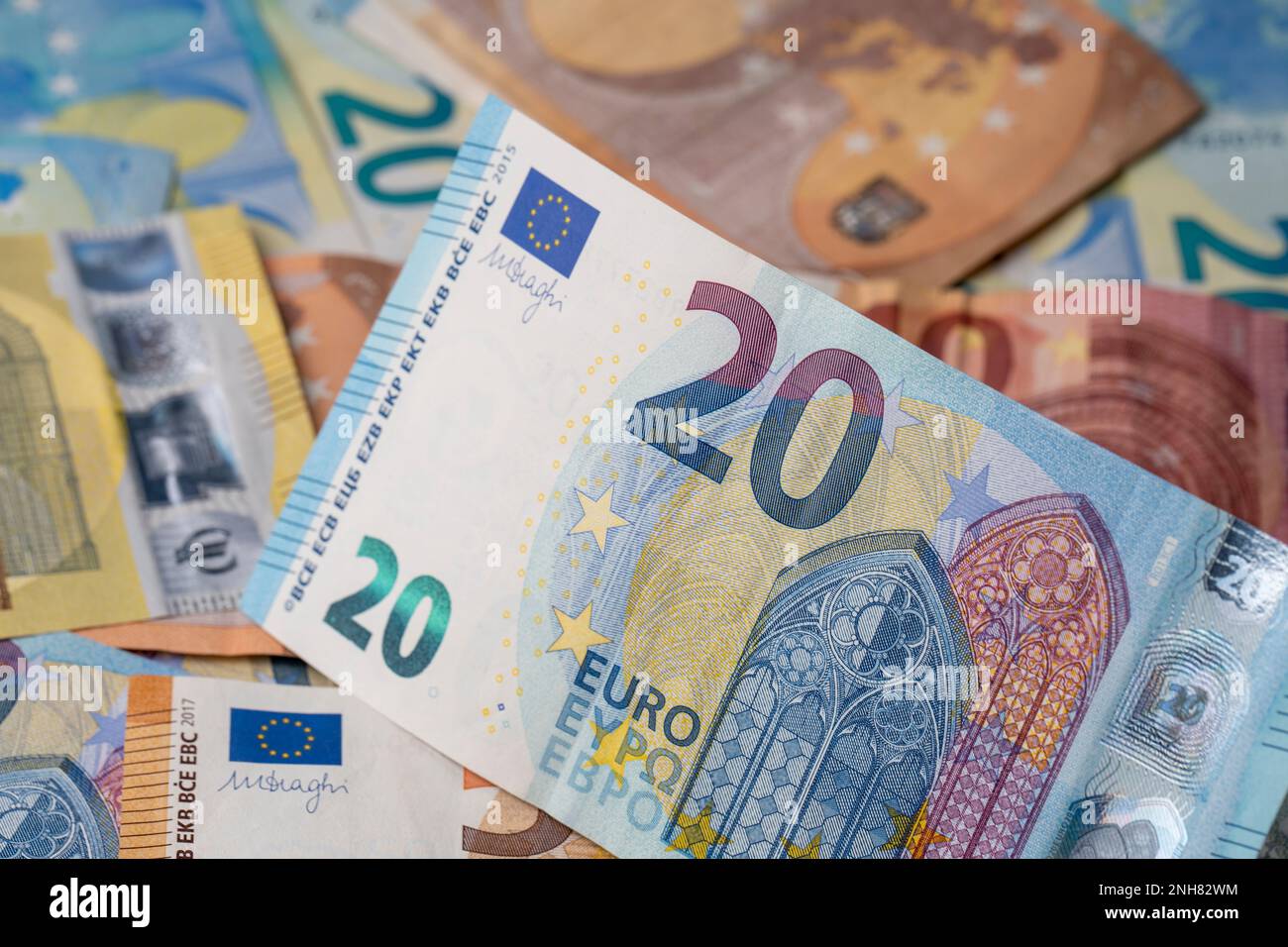 Ein Stapel Banknoten auf dem Tisch. 20 Euro Geldstückelung in Papierform im Fokus. Gemischte Euro-Banknoten im Hintergrund. Stockfoto