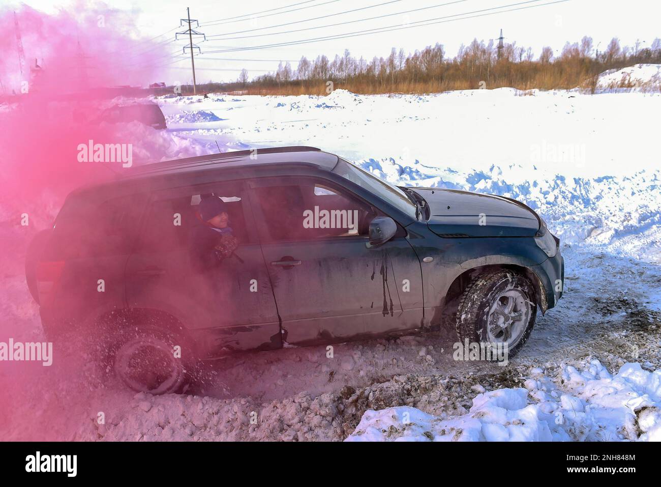Off-Road-Auto „Suzuki Grand Vitara“ 4x4 aktiv und schnell in einem karmesinroten Rauch. Stockfoto