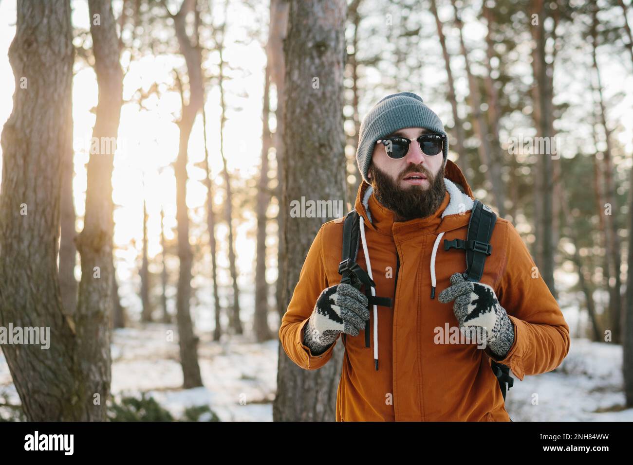 Wandermännchen mit Rucksack im verschneiten Winterwald Stockfoto
