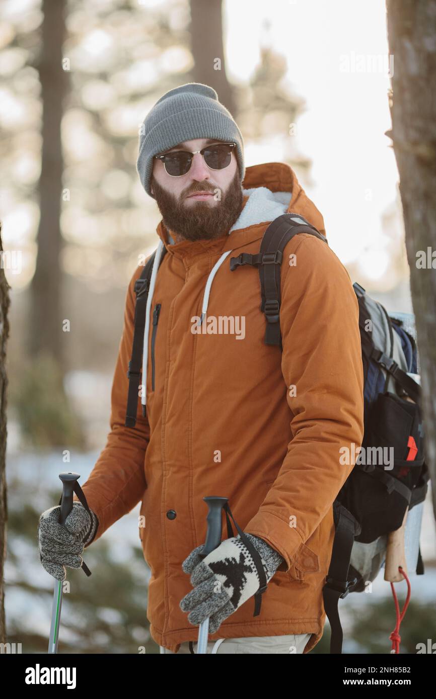 Wanderer in Bergwäldern mit Accessoires für kaltes Wetter, Windjacke und Rucksack für Camping im Freien. Der Typ porträtiert den Lebensstil. Stockfoto